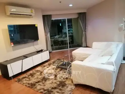 Spacious modern living room with stylish furniture and city view balcony.