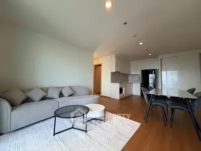 Spacious modern living room with open kitchen and elegant dining area, perfect for entertaining.