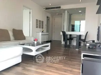 Modern living room with sleek furniture and open layout, featuring hardwood floors and contemporary decor.