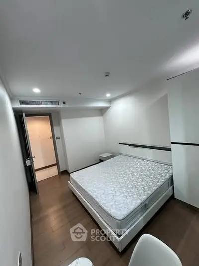 Spacious bedroom with modern design and hardwood flooring