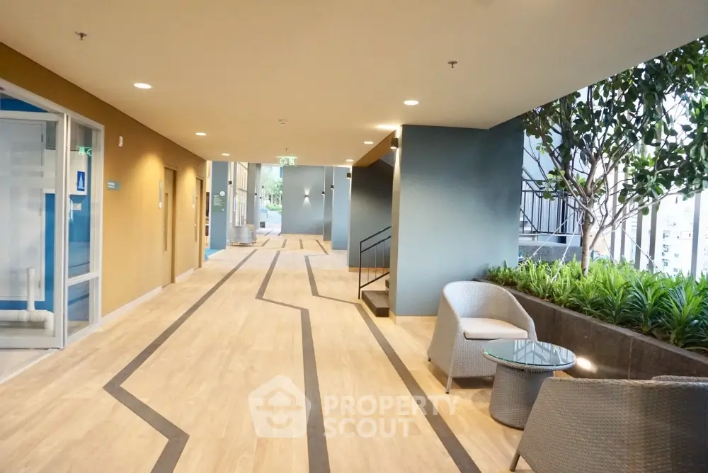 Modern building entrance with stylish seating and greenery