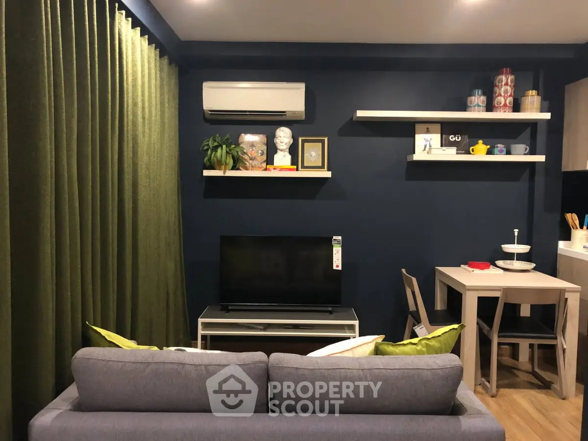 Cozy living room with modern decor and dining area, featuring a sleek TV setup and stylish shelving.