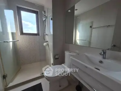 Modern bathroom with glass shower and sleek fixtures in a bright, contemporary home.