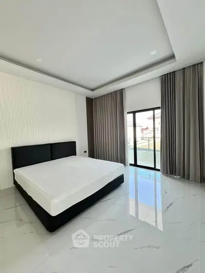 Spacious modern bedroom with large windows and elegant curtains