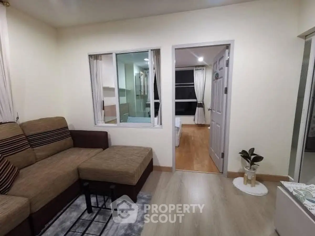Cozy living room with sectional sofa and view into adjacent bedroom, perfect for modern living.