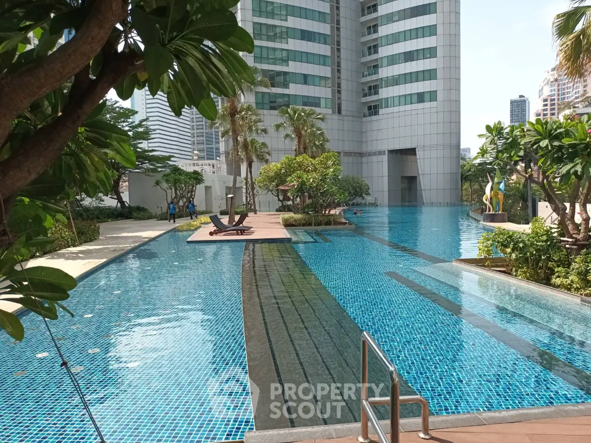 Luxurious high-rise building with stunning outdoor pool and lush greenery, perfect for urban living.