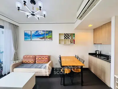 Modern living room with cozy sofa, dining area, and compact kitchen in open layout.