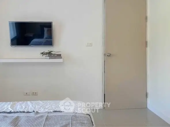 Modern bedroom with wall-mounted TV and minimalist decor