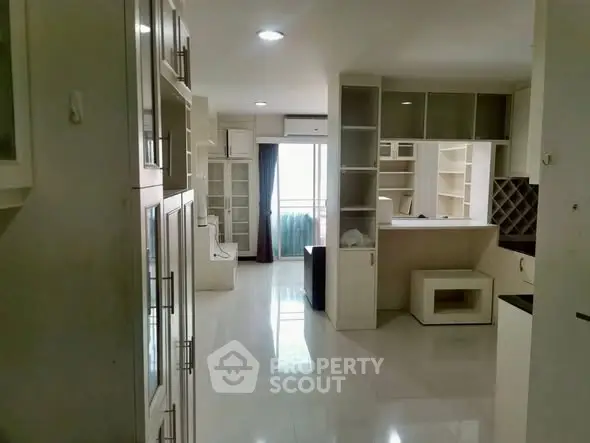 Spacious modern living room with built-in shelves and bright natural light.