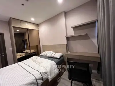 Modern bedroom with stylish furniture and cozy ambiance, featuring a comfortable bed and sleek desk area.