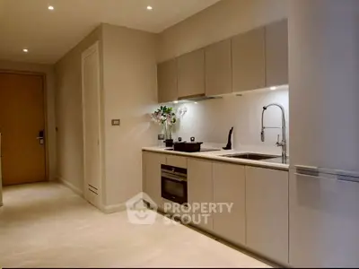 Modern kitchen with sleek cabinetry and built-in oven in a stylish apartment.