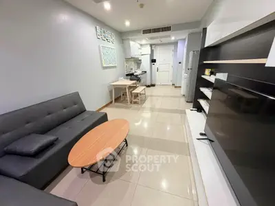 Modern living room with sleek furniture and open kitchen layout in a stylish apartment.