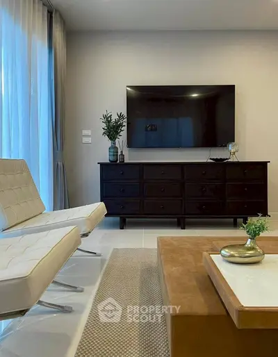 Modern living room with sleek furniture and large TV, perfect for relaxation.