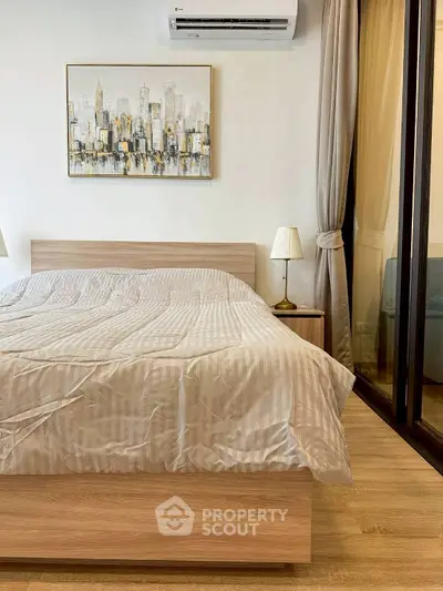 Modern bedroom with stylish decor and cityscape artwork, featuring a cozy bed and elegant lighting.