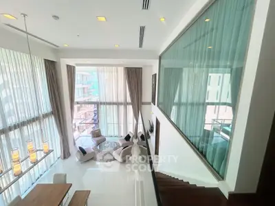 Luxurious modern living room with high ceilings and large windows offering stunning views.