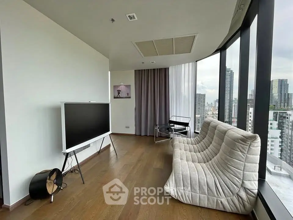 Modern living room with panoramic city views and stylish furniture in a high-rise apartment.