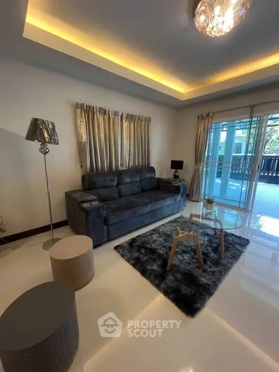 Modern living room with plush sofa, stylish lighting, and balcony access in a chic apartment.
