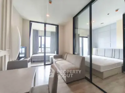 Modern apartment interior with spacious living room and bedroom, featuring sleek glass partitions.