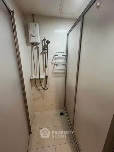 Compact bathroom with shower and water heater in modern apartment