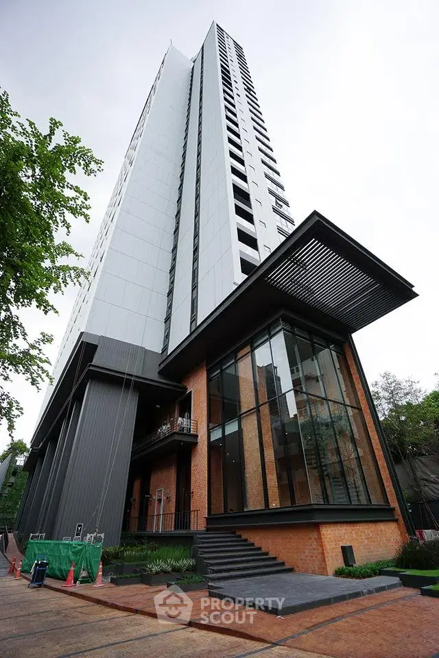 Modern high-rise building with sleek design and large glass windows in urban setting.