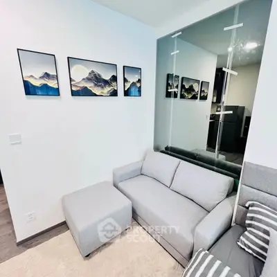Modern living room with stylish gray sofa and mountain artwork, perfect for cozy relaxation.