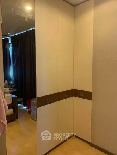 Spacious bedroom with modern wardrobe and wooden flooring