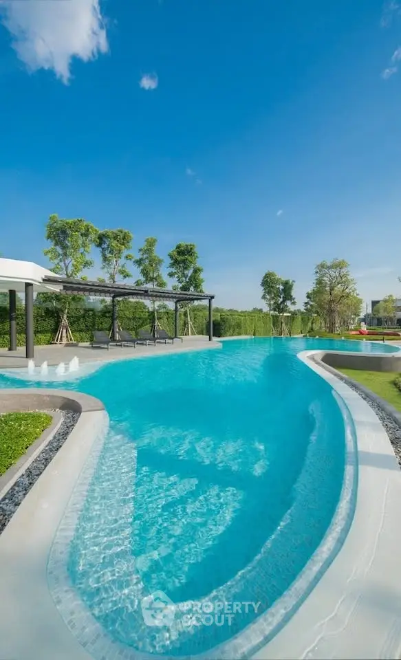 Luxurious outdoor pool with clear blue water and scenic greenery, perfect for relaxation and leisure.