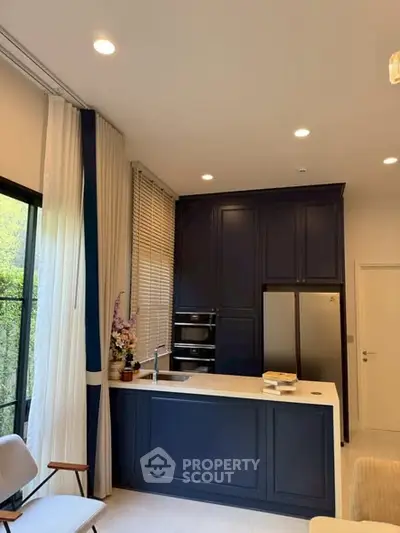 Modern kitchen with navy cabinets and stainless steel appliances