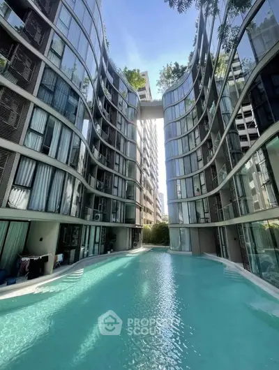 Luxurious modern apartment complex with stunning pool and unique architectural design.