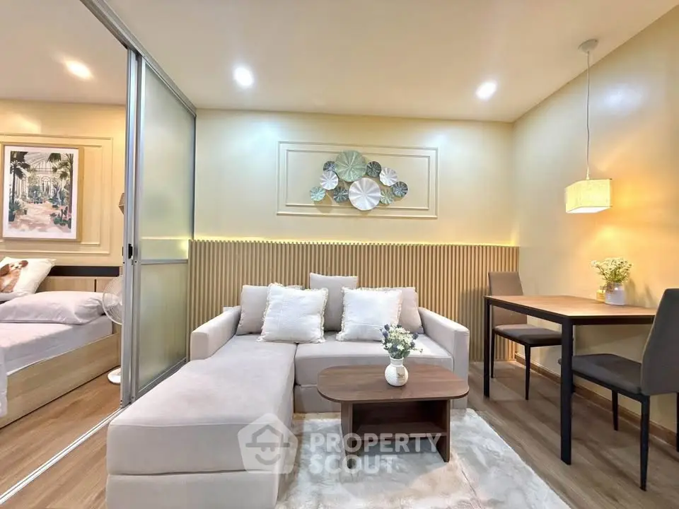 Modern living room with cozy sofa, elegant decor, and dining area in stylish apartment.