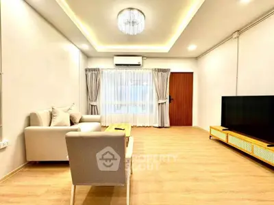 Spacious modern living room with elegant lighting and cozy seating area.