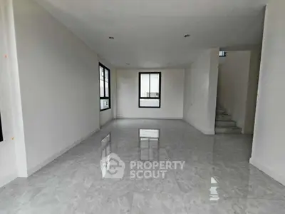 Spacious modern living room with glossy tiled floors and large windows.