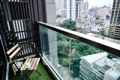Modern balcony with city view and cozy seating area, perfect for relaxation.
