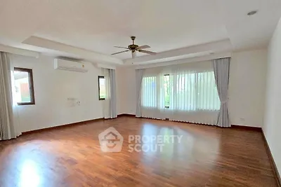 Spacious empty living room with wooden flooring and large windows