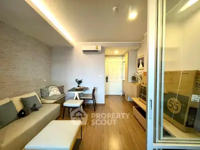Modern living room with stylish decor and natural light, featuring a cozy seating area and sleek wooden flooring.