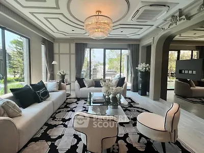 Luxurious living room with elegant decor and large windows offering garden views.