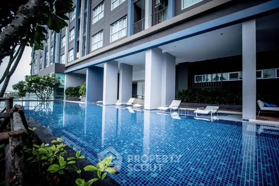 Luxurious modern apartment building with stunning poolside view and sleek architectural design.