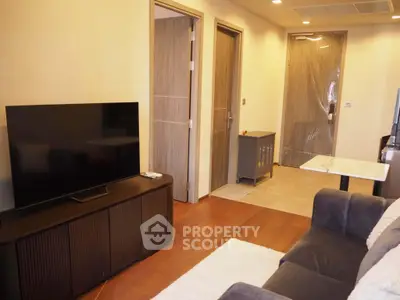 Modern living room with sleek TV setup and cozy seating area in stylish apartment.