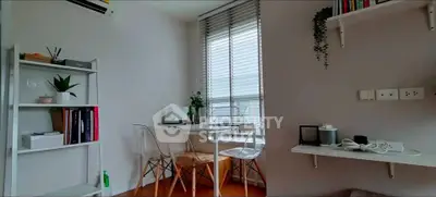 Modern study area with natural light, sleek furniture, and minimalist decor in a cozy apartment.