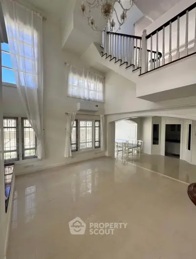 Elegant spacious living room with high ceilings and chandelier, perfect for luxury living.