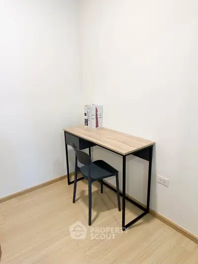 Minimalist study nook with sleek desk and chair in modern apartment.