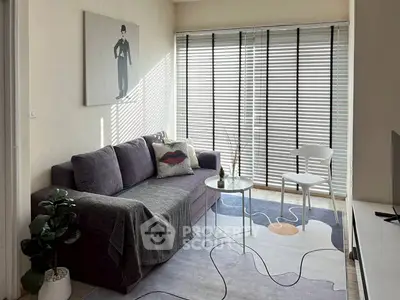 Charming living room with modern decor, cozy sofa, and natural light through large windows.