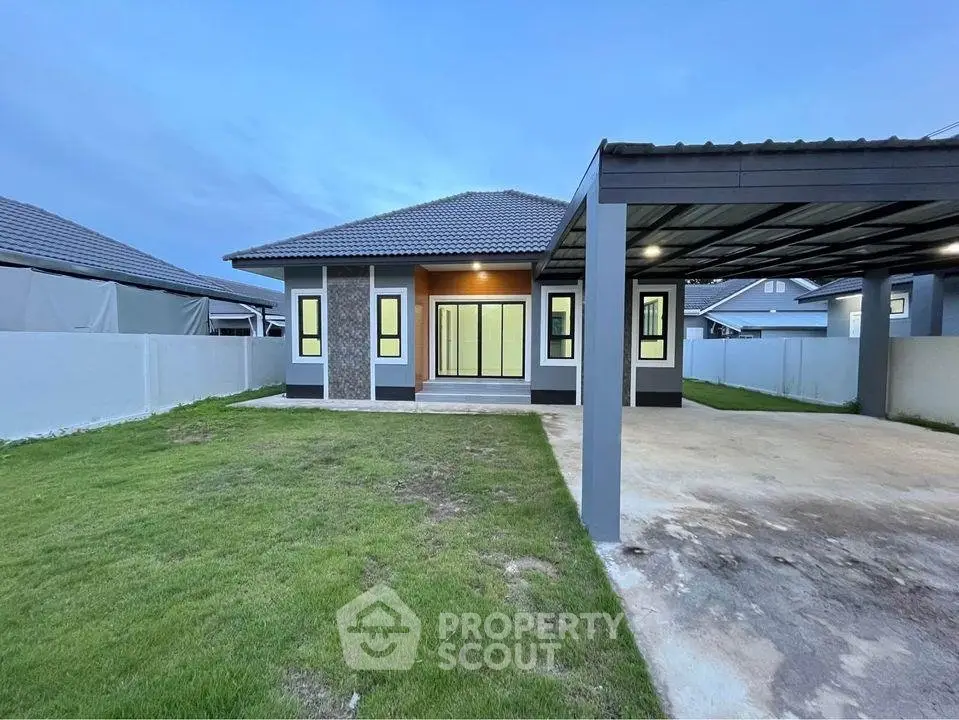 Modern single-story house with spacious carport and lush green lawn
