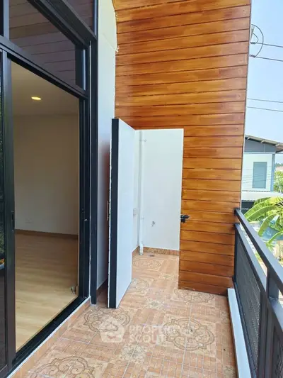 Charming balcony with wooden paneling and tiled floor, perfect for relaxation and enjoying outdoor views.