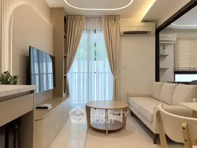Modern living room with elegant decor, featuring a cozy sofa, stylish coffee table, and large flat-screen TV.