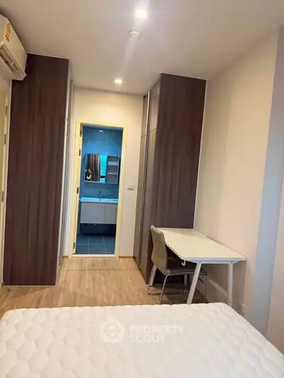 Modern bedroom with ensuite bathroom and study area in a stylish apartment.