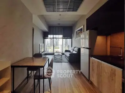 Modern living room with city view, sleek furniture, and open kitchen layout.