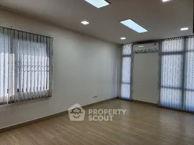 Spacious modern living room with large windows and wooden flooring