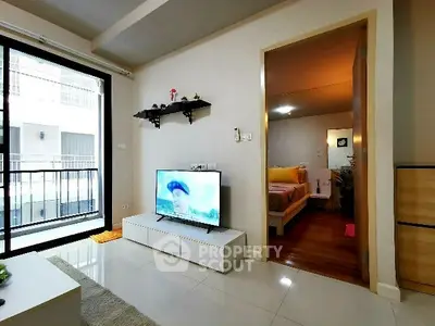 Modern living room with sleek TV setup and cozy bedroom view