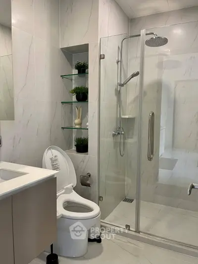 Modern bathroom with glass shower and sleek fixtures in a stylish apartment.